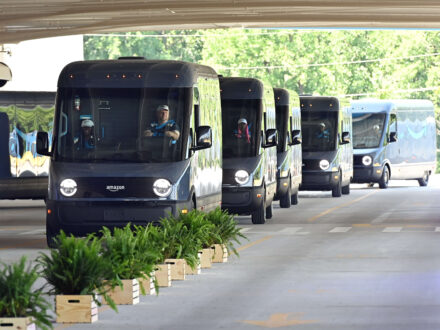 Rivian Amazon delivery trucks driving in line on the road